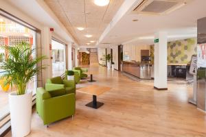 an office lobby with green chairs and a table at Hotel Gala Placidia 3'''sup in Benidorm