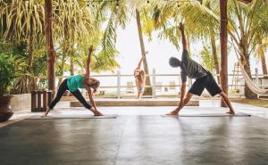two people doing a yoga pose on a yoga mat at Encantada Ocean Cottages in Esterillos Este