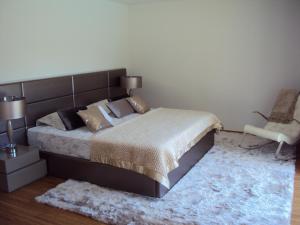 ein Schlafzimmer mit einem großen Bett und einem Stuhl in der Unterkunft Villa Piscine Portugal in Coucieiro + 38 Fotos
