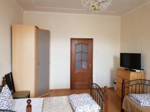 a bedroom with two beds and a flat screen tv at Версаль на Брестской in Moscow