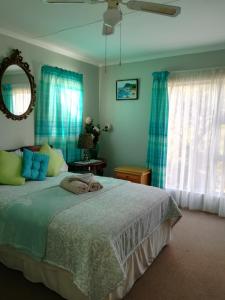a bedroom with a large bed with blue curtains at Avondsrus Guesthouse in Bettyʼs Bay