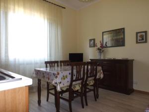 Un comedor con mesa y sillas y una ventana. en Casa dei Pini, en Cortona
