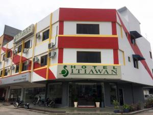 een gebouw met motoren die ervoor geparkeerd staan bij Hotel Sitiawan in Sitiawan