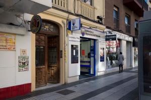 a person walking down a street in front of stores at Apartment Alcala 146 in Madrid