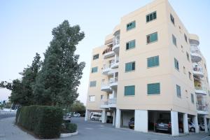 a tall building with cars parked in front of it at Bianco E U Apartment in Nicosia
