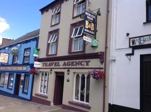 a building with a travel agency sign on the side of it at Sraid Eoin House in Dingle