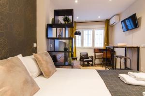 マドリードにあるMinty Stay - Pedro Zeroloのベッドルーム(白いベッド1台付)、リビングルームが備わります。