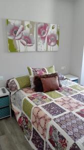 a bedroom with a bed with a quilt on it at Apartamento Vintage Benidorm in Benidorm