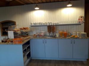 a kitchen with blue cabinets and a counter with food at Hotel Alpenblick Mürren in Mürren