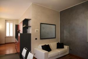 una sala de estar con un sofá blanco con almohadas negras en Gaudio 22 Apartment en San Remo