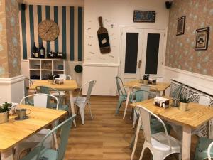 un restaurante con mesas y sillas de madera y un reloj en la pared en Green Hostel Galicia, en Silleda