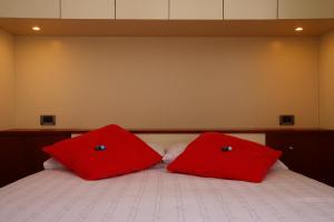 two red pillows sitting on top of a bed at Gaudio 22 Apartment in Sanremo