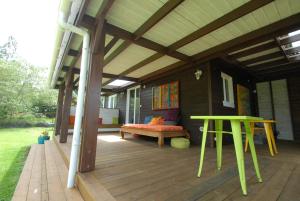 a covered deck with a bench and a table at belle la vie in La Plaine des Cafres