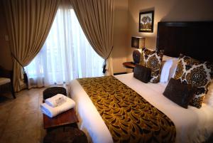 a hotel room with a large bed and a window at Kathuhari Guesthouse in Kathu