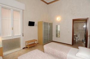 ein Schlafzimmer mit zwei Betten und einem Fernseher in der Unterkunft Castelfranco Hotel in Castelfranco Emilia