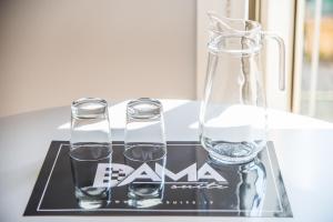ナポリにあるDama Suiteの水のグラス2杯とテーブルの上の花瓶