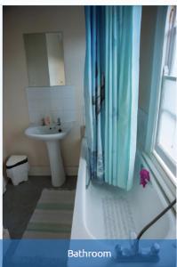 ein Badezimmer mit einer Badewanne und einem Waschbecken in der Unterkunft Rooms To Let In London in London