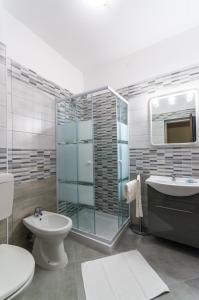 リニャーノ・サッビアドーロにあるHotel Romantikのバスルーム(ガラス張りのシャワー、トイレ、シンク付)