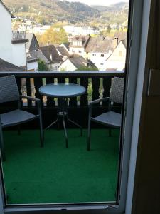 een tafel en stoelen op een balkon met uitzicht bij Gästehaus Spies in Bullay