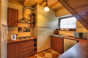 uma cozinha com armários de madeira e um lavatório em Pokoje Gościnne Pod Giewontem em Zakopane