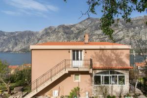 a house with a staircase in front of a mountain at Lux Apartments Fabris in Kotor
