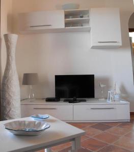 a living room with a tv and a table at Case Vacanze - Le Bacche di Maiorca in Budoni