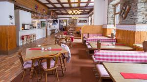 Alpenhaus Kesselfall في كابرون: مطعم فيه طاولات وكراسي في الغرفة