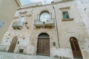 un edificio in mattoni con due porte e un balcone di B&B Antichemura a Francavilla Fontana