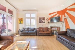 ein Wohnzimmer mit zwei Sofas und einem Kamin in der Unterkunft Hootananny Hostel in London