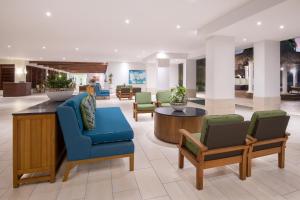 eine Lobby eines Hotels mit Stühlen und Tischen in der Unterkunft All Inclusive Holiday Inn Resort Aruba - Beach Resort & Casino, an IHG Hotel in Palm-Eagle Beach