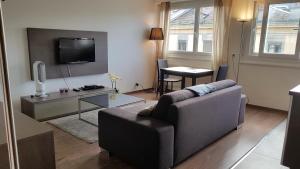 a living room with a couch and a tv and a table at EV55 in Geneva