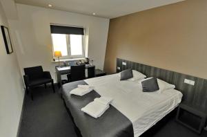 una camera da letto con un grande letto con asciugamani bianchi di Hotel Parkview ad Amsterdam