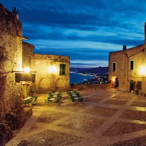 an old building with chairs in a courtyard at night at Albergo Calcagno in Borgio Verezzi