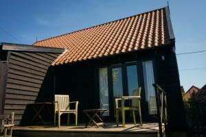 a house with chairs and a table on a porch at Fox Inn in Darsham