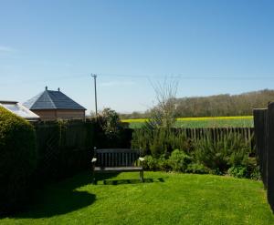 a park bench in a yard with a fence at Fox Inn in Darsham