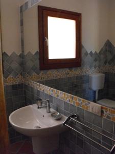 a bathroom with a sink and a window at Case Vacanze - Le Bacche di Maiorca in Budoni