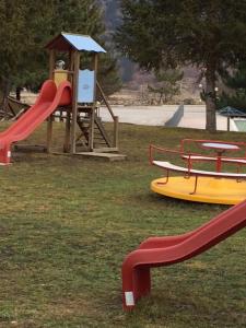 einen Park mit Spielplatz mit Rutsche und Spielgeräten in der Unterkunft RESIDENCE ALTAIR Via Roma 13 in Ovindoli