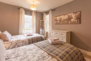 a bedroom with two beds and a window at Marina View Apartment in Inverkip