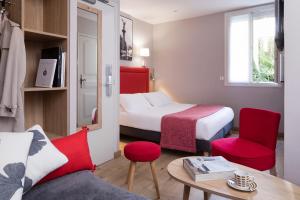 Hotel Daumesnil-Vincennes في فينسين: غرفة فندقية بسرير وطاولة وكراسي