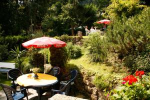 einen Tisch und Stühle mit Sonnenschirm in einem Garten in der Unterkunft Apartment Haus Schatz in Kitzbühel