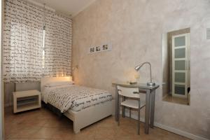 ein Schlafzimmer mit einem Bett, einem Tisch und einem Schreibtisch in der Unterkunft Castelfranco Hotel in Castelfranco Emilia