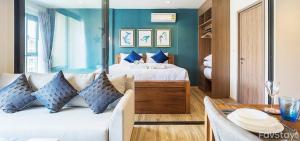 um quarto com uma cama com paredes azuis e uma mesa em Rain Cha-am Huahin By Sake em Cha Am