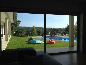 ein Wohnzimmer mit Blick auf den Pool durch ein Fenster in der Unterkunft Villa Piscine Portugal in Coucieiro