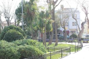 a park with a black fence and trees and bushes at Sultans Hotel in Istanbul