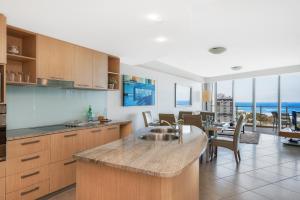 a kitchen with wooden floors and a large window at The Sebel Maroochydore in Maroochydore