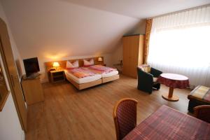 フォルカッハにあるAppartements Leiboldのベッドとリビングルームが備わるホテルルームです。