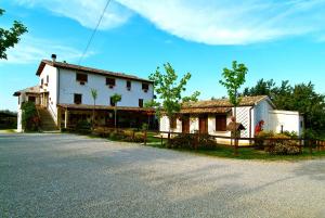a white house and a building on the side of a road at Agriturismo Il Portico in Penne