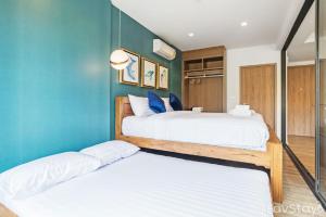 two beds in a room with blue walls at Rain Cha-am Huahin By Sake in Cha Am