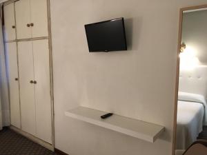 a room with a television on a wall with a shelf at Hotel Derli Sella in Ribadesella +38 photos