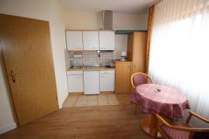 uma pequena cozinha com uma mesa, um lavatório e um balcão em Appartements Leibold em Volkach